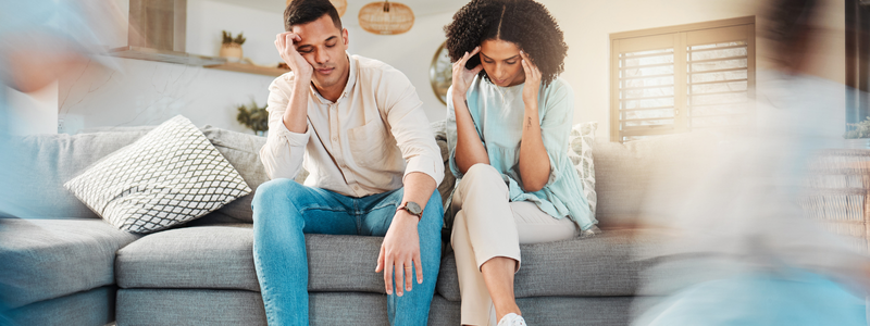 זוג יושב על ספה ונראה תשוש, מסביב ילדים רצים